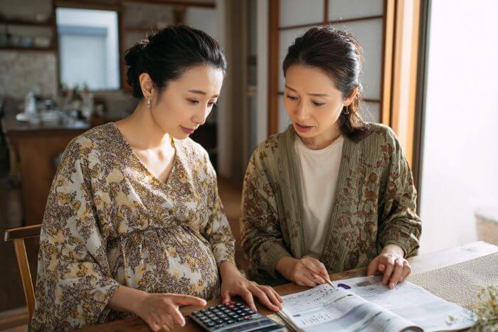 困った表情の妊婦と実家の母親