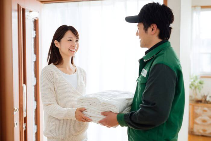 清潔な布団を受け取る安心した表情の妊婦